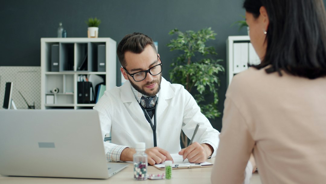 Patient and clinician reviewing treatment history during a medical visit